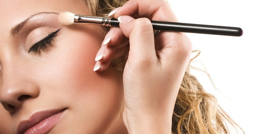 Makeup artist applying flesh-coloured eyeshadow